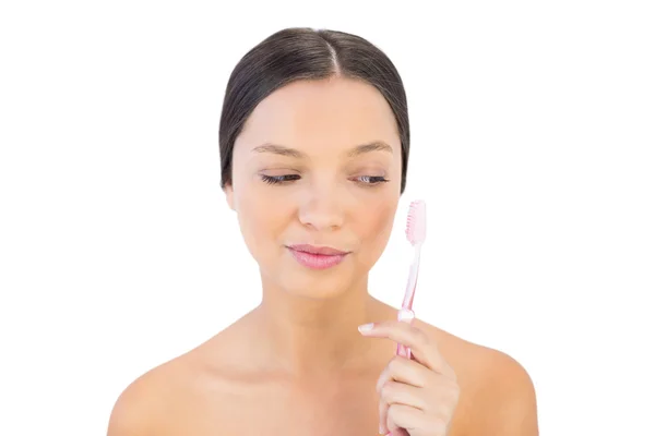 Morena mulher olhando para sua escova de dentes — Fotografia de Stock
