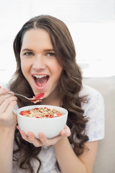 Carino giovane donna in pigiama mangiare cereali fruttati — Foto Stock