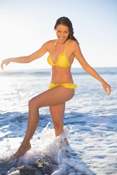 Glückliche wunderschöne Frau im gelben Bikini, die Spaß im Meer hat — Stockfoto