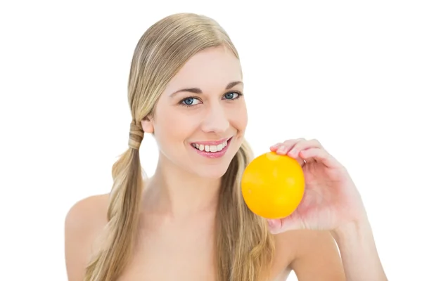 Sonriente joven rubia sosteniendo una naranja — Foto de Stock