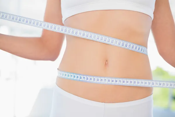 Mujer delgada midiendo su cintura durante la dieta — Foto de Stock