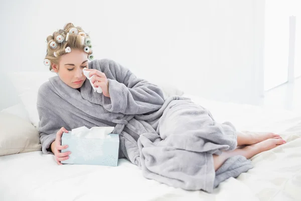 Mujer rubia triste en rulos de pelo llorando y usando pañuelos —  Fotos de Stock