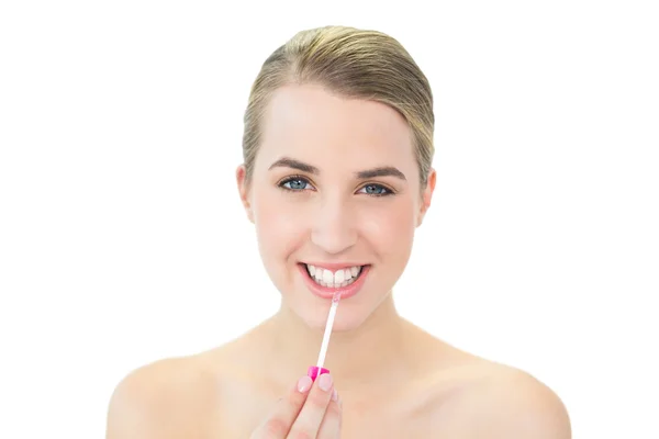 Lächelnde attraktive Blondine, die Lipgloss aufträgt — Stockfoto