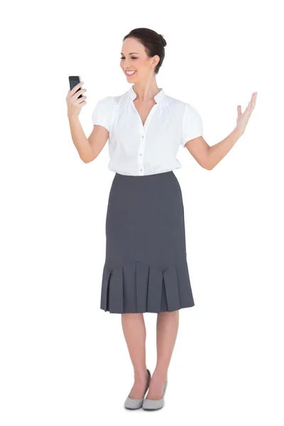 Glimlachende zakenvrouw kijken naar haar telefoon — Stockfoto