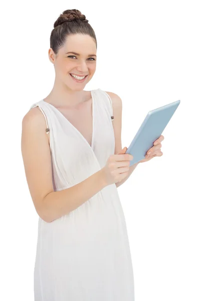 Cheerful young model in white dress holding tablet pc — Stock Photo, Image