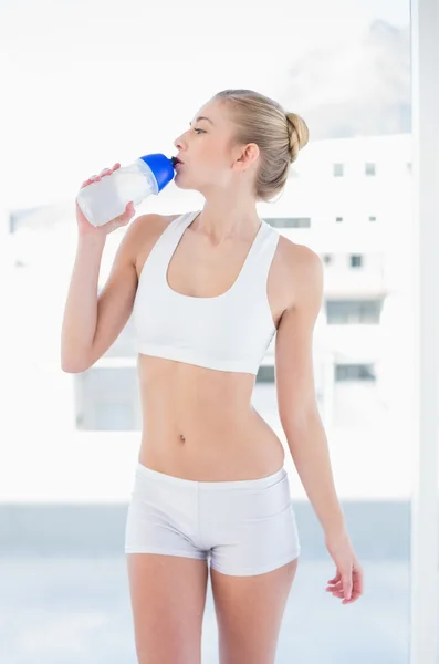 Привлекательная молодая блондинка-модель пьет воду в бутылке — стоковое фото