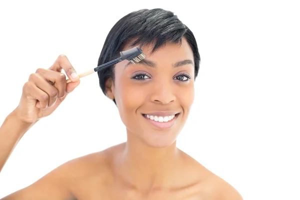 Feliz mujer de pelo negro cepillándose las cejas —  Fotos de Stock