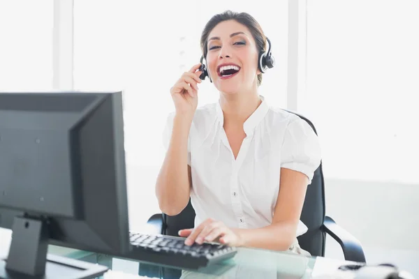Glada samtal centrum agent sitter vid hennes skrivbord på ett samtal — Stockfoto