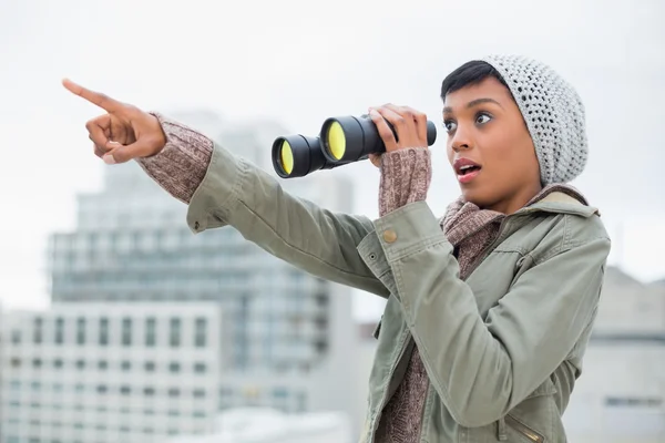 Schockiertes junges Model in Winterkleidung zeigt etwas am Himmel — Stockfoto
