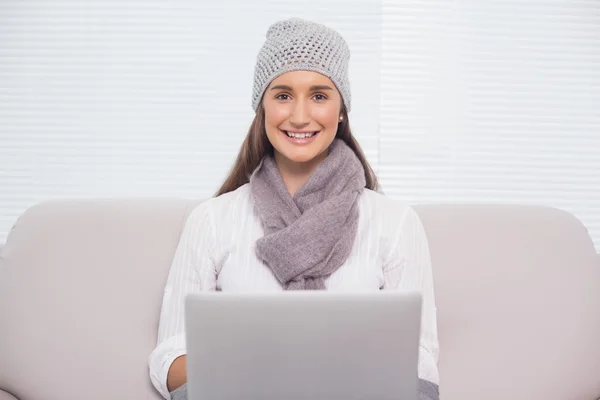 Brune souriante avec chapeau d'hiver sur l'utilisation de son ordinateur portable — Photo