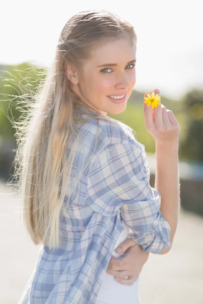 Woman holding yellow flower in hand — Stock Photo, Image