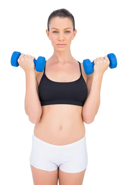 Focused sporty brunette working out with dumbbells — Stock Photo, Image