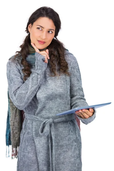 Nadenkend model dragen van winter kleding bedrijf haar Tablet PC — Stockfoto