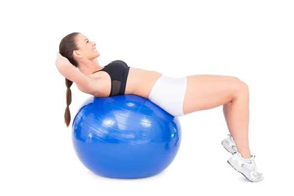 Mujer sonriente en forma haciendo ejercicio con pelota de ejercicio —  Fotos de Stock