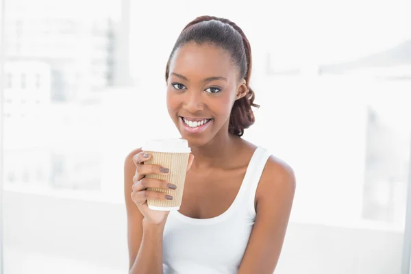 Sonriente mujer deportiva sosteniendo café —  Fotos de Stock