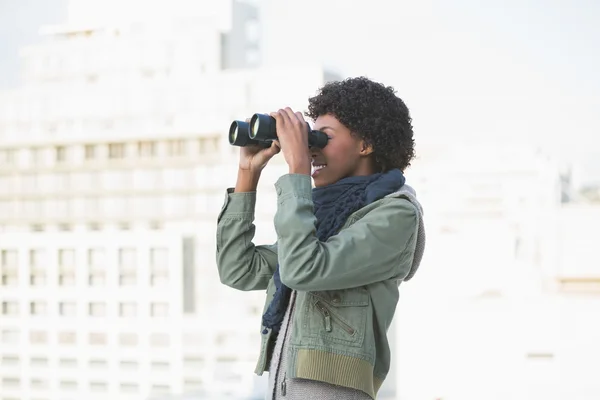 Vrolijke casual model op zoek door middel van verrekijkers — Stockfoto