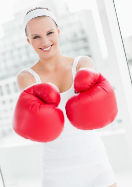 Laughing pretty sportswoman showing her boxing gloves — Stock Photo, Image