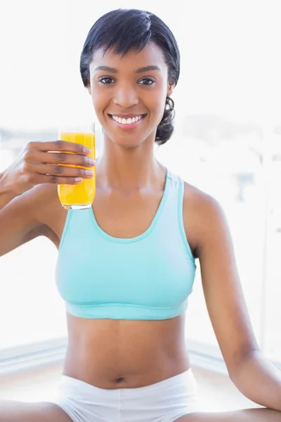 Mulher em forma relaxada desfrutando de um copo de suco de laranja — Fotografia de Stock