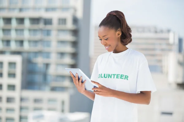 Женщина в футболке волонтера с планшетным ПК — стоковое фото