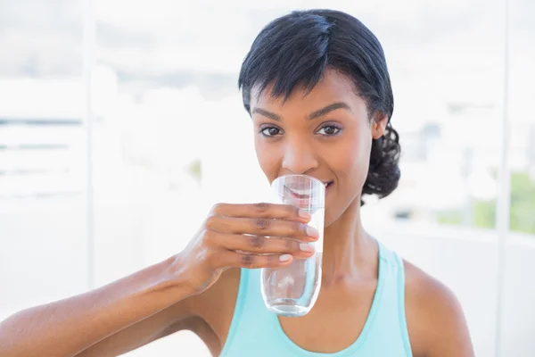 Encantadora mulher de cabelos pretos bebendo um copo de água — Fotografia de Stock