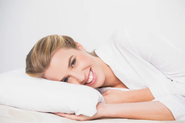 Sorridente modello carino sdraiato sul letto accogliente — Foto Stock