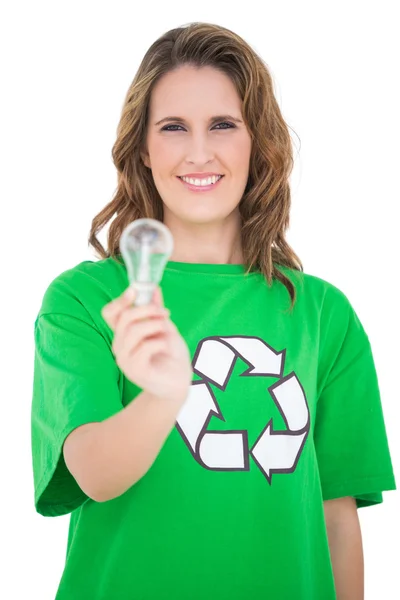 Smiling environmental activist holding light bulb looking at camera — Stock Photo, Image