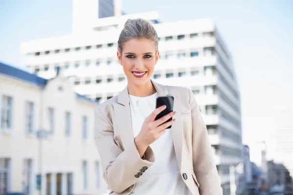 Happy attractive businesswoman sending a text message — Stock Photo, Image