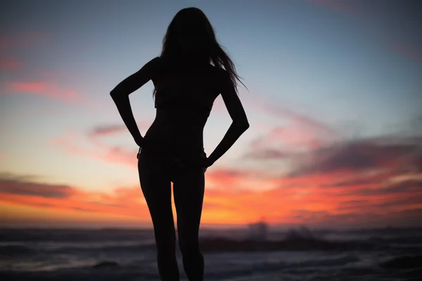 Silhouette di donna magra in posa sulla spiaggia — Foto Stock