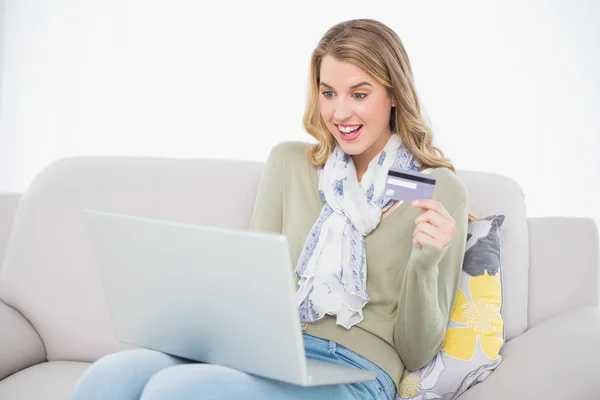 Zaskoczony cute blondynka przy użyciu jej karty kredytowej, aby kupić online Obraz Stockowy