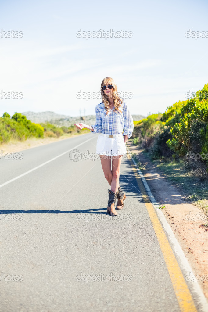 Trendy blonde with sunglasses hitchhiking