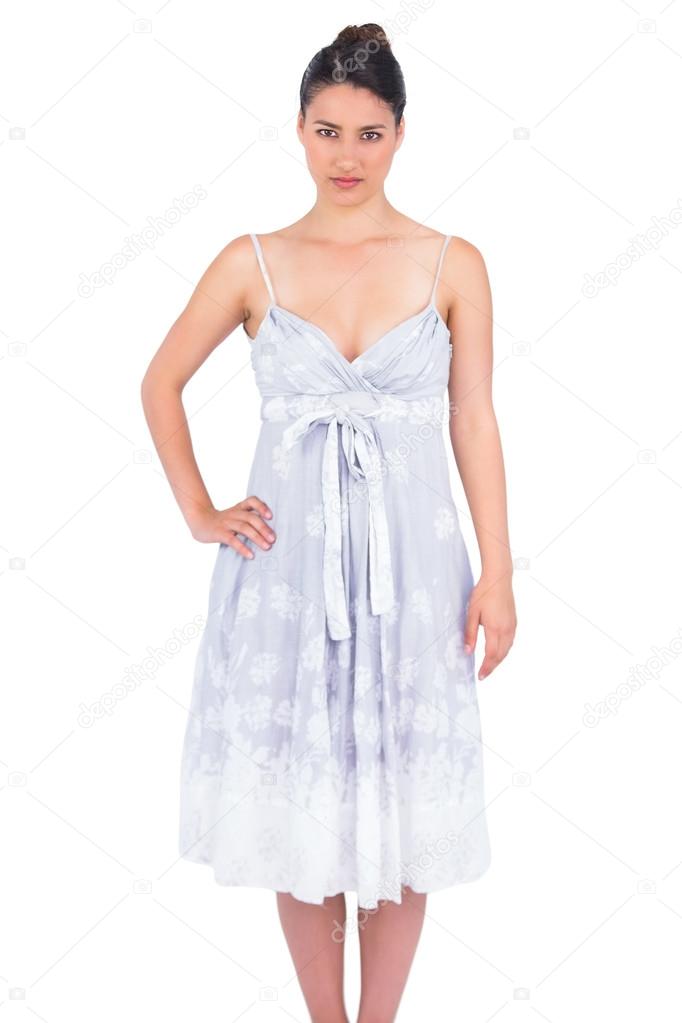 Serious seductive young model in summer dress posing