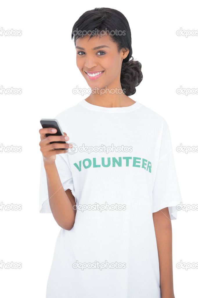 Charming black haired volunteer texting with her mobile phone