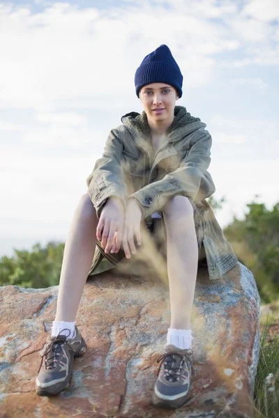 Mujer con gorra sentada en piedra —  Fotos de Stock