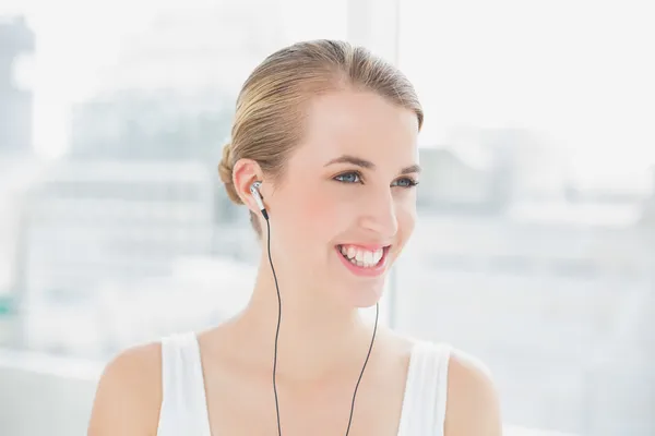 Tiro na cabeça de uma mulher sorridente e desportiva ouvindo música — Fotografia de Stock