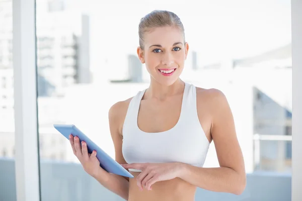 Glad ung blond modell håller en TabletPC — Stockfoto