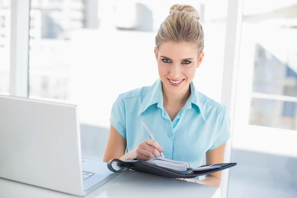 Alegre mujer de negocios bien vestida escribiendo en la agenda — Foto de Stock