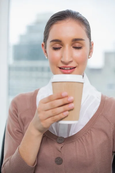 Happy gorgeous businesswoman smelling coffee — Stock Photo, Image