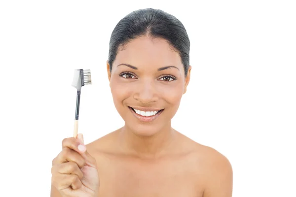 Smiling black haired model holding eyebrow brush — Stock Photo, Image
