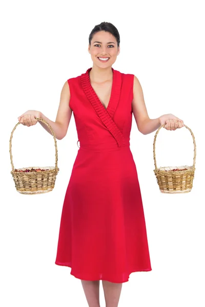 Glada glamorös modell i röd klänning håller korgar — Stockfoto