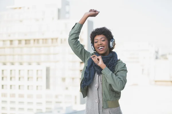 Cheerful casual model dancing while listening to music — Stock Photo, Image