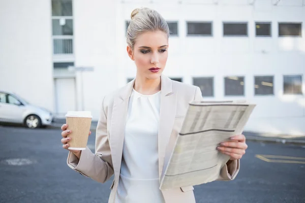 Strenge stylische Geschäftsfrau liest Zeitung — Stockfoto