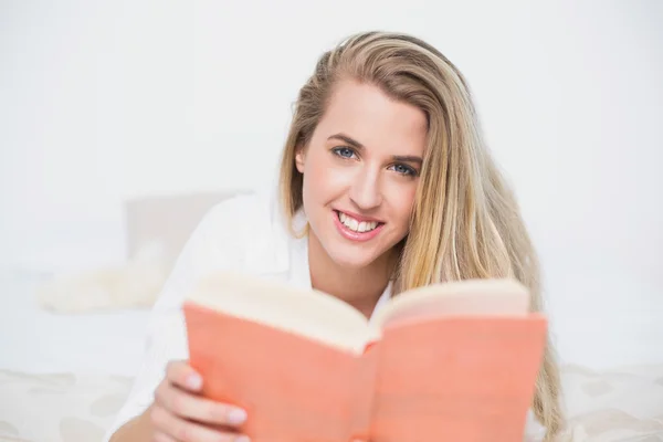 Feliz hermosa modelo tumbado en la cama acogedora libro de lectura —  Fotos de Stock