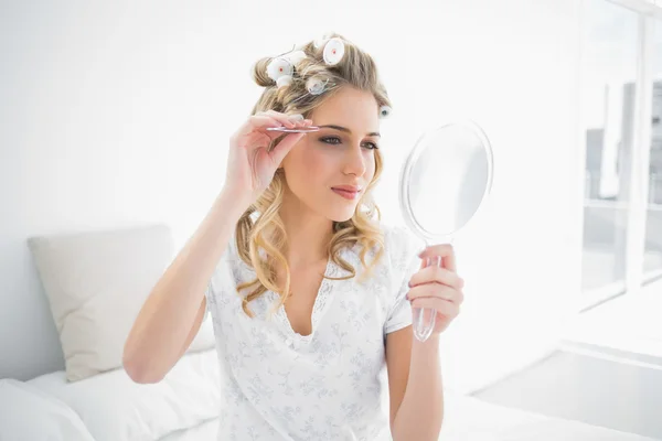 Friedliche natürliche Blondine mit Pinzette auf der Augenbraue — Stockfoto