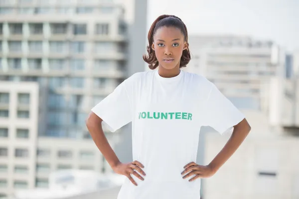 Seriózní žena s rukama na boky nošení dobrovolníků tričko — Stock fotografie