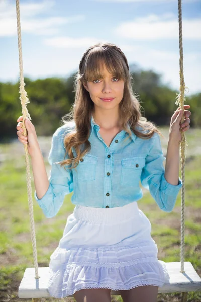 Peaceful young model relaxing while sitting on swing — Stock Photo, Image