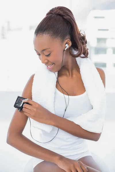 Sonriente atlética mujer cambiando música en su mp3 —  Fotos de Stock