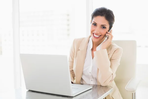 Donna d'affari felice che lavora con un computer portatile al telefono — Foto Stock