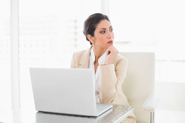 Mujer de negocios reflexiva que trabaja con un ordenador portátil —  Fotos de Stock