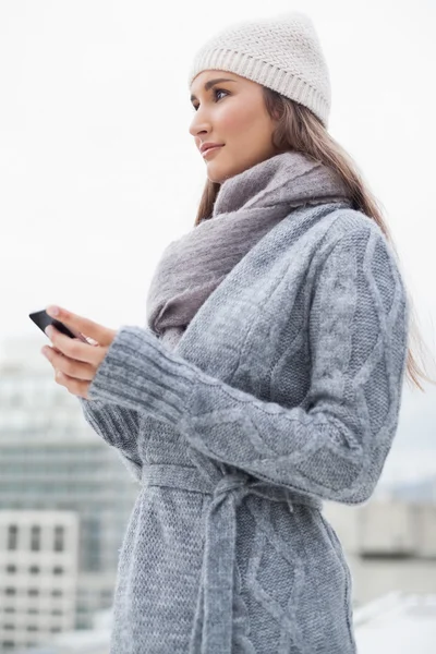 Friedliche Frau mit Winterkleidung auf SMS — Stockfoto