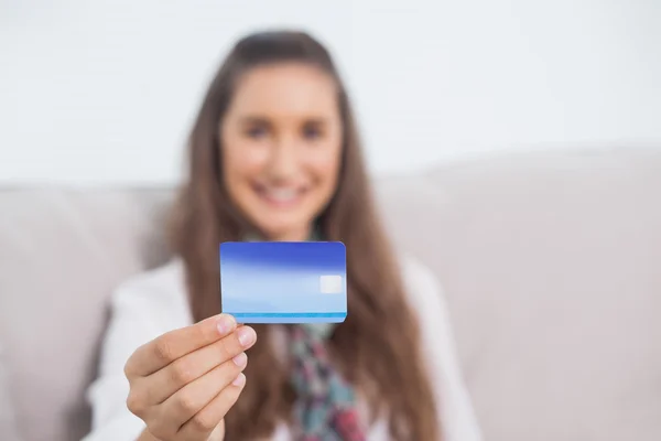 Cheerful young model holding her credit card — Stock Photo, Image